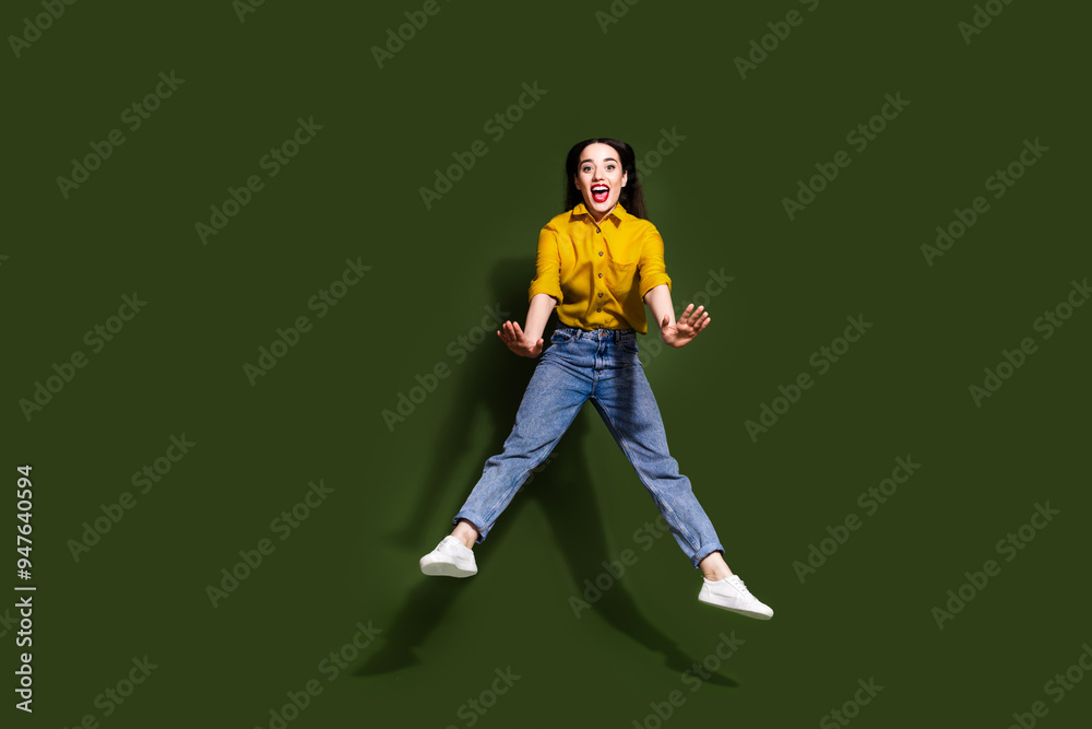 Full length photo of cheerful pretty lady dressed yellow blouse jumping high empty space isolated khaki color background Full length photo of cheerful pretty lady dressed yellow blouse jumping high empty space isolated khaki color background