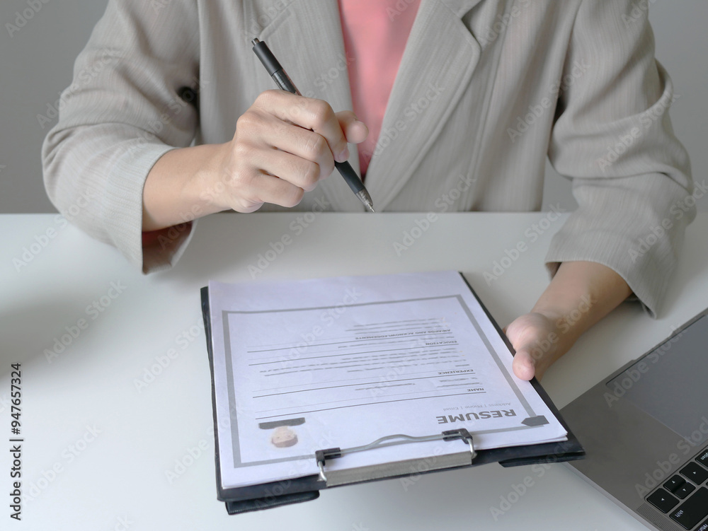 Business woman employer holds resume of job applicant to analyze data before job interviews. Regarding personnel recruitment Business woman employer holds resume of job applicant to analyze data before job interviews. Regarding personnel recruitment