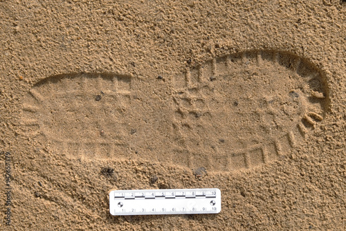 Shoe print in sand with scale ruler, three-dimensional visible trace evidence, crime scene examination, forensic examination of traces