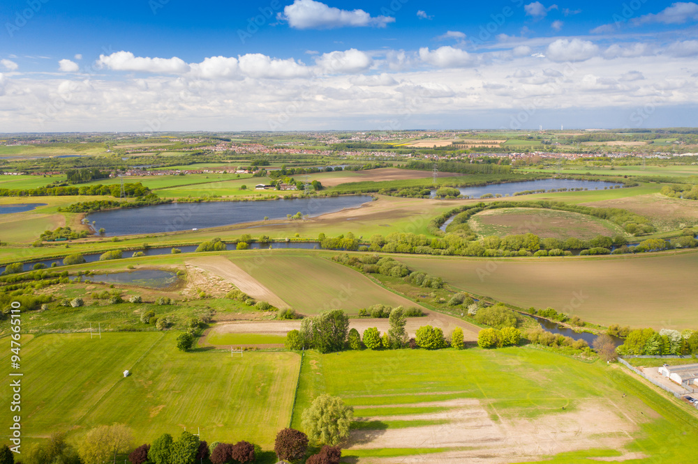 Naklejka premium Aerial country side photo of a beautiful spring time scenic view with blue sky and fluffy white clouds located in the village of Castleford in Wakefield West Yorkshire in the UK