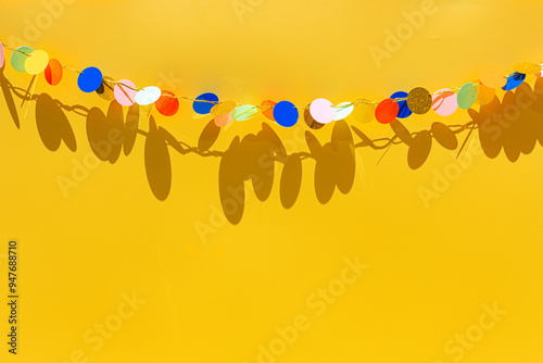 Colorful birthday garland against yellow background