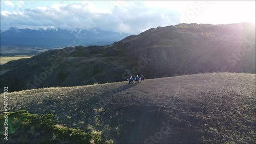 Group of people relaxing on chairs in the mountains, aerial view at sunset. Travel vacation on nature.