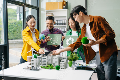 Group of diverse multiethnic businesspeople standing neare table looking at model of building from residential project. Green business company photo