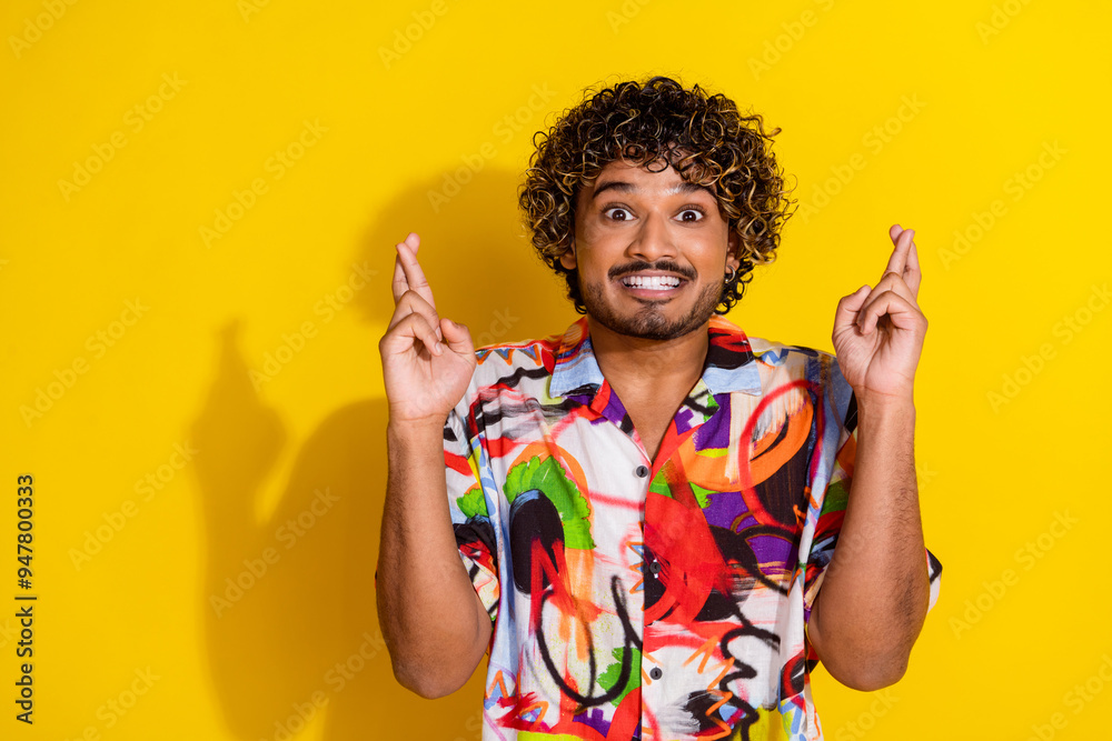 Photo of nice young man crossed fingers wear shirt isolated on yellow color background Photo of nice young man crossed fingers wear shirt isolated on yellow color background