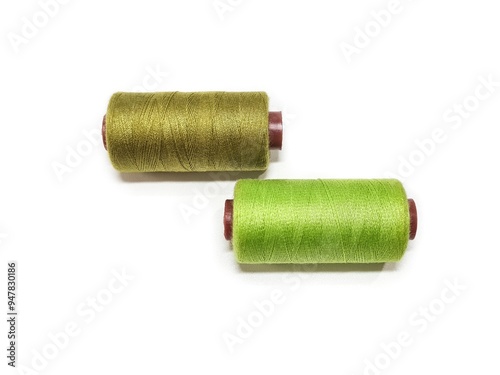 Set of sewing threads on a white background. Two spools of sewing thread. Olive Green dan Lime Green color threads isolated. photo