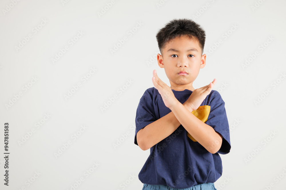 Portrait Asian young kid boy unhappy or confident standing holding two cross arms say no X sign, studio shot isolated white background, Thai primary child pose reject gesture with copy space Portrait Asian young kid boy unhappy or confident standing holding two cross arms say no X sign, studio shot isolated white background, Thai primary child pose reject gesture with copy space