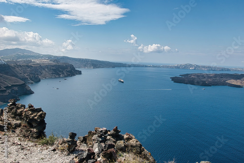 View of Skaros rock, a rocky headland that protrudes out to the azure blue Aegean Sea, Imerovigli, Santorini, Greece. This was on a hot sunny afternoon. photo