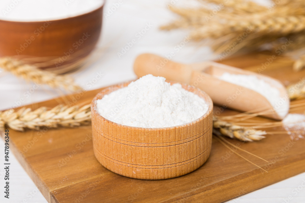 Flat lay of Wheat flour in wooden bowl with wheat spikelets on colored background. world wheat crisis Flat lay of Wheat flour in wooden bowl with wheat spikelets on colored background. world wheat crisis
