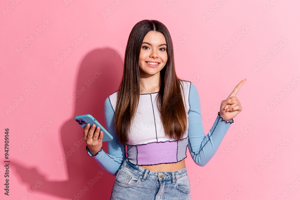 Photo of lovely charming girl wear trendy clothes hold gadget empty space banner isolated on pink color background Photo of lovely charming girl wear trendy clothes hold gadget empty space banner isolated on pink color background