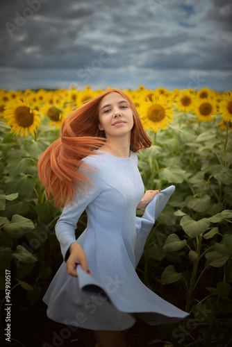 Girl in the dress posing in the meadow of sunflowers. photo