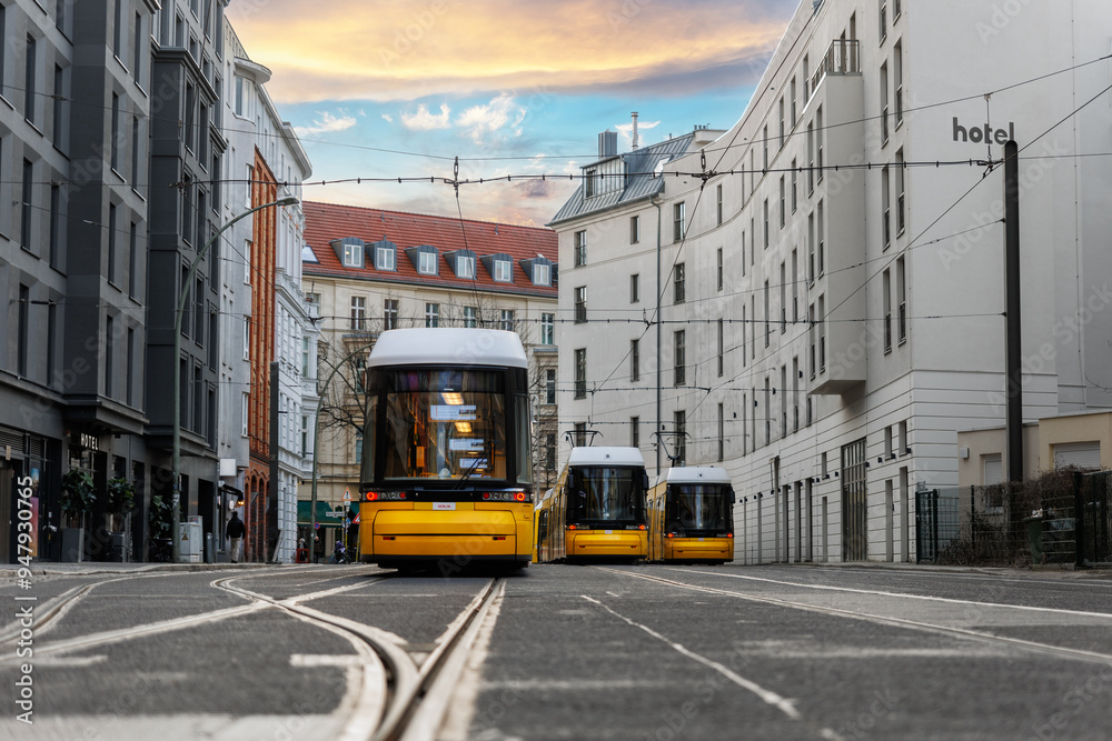 Scenic evening view many modern yellow tram car parked at street station Berlin Mitte central district at dusk warm sunset. Urban european transport commute cityscape Germany scene background Scenic evening view many modern yellow tram car parked at street station Berlin Mitte central district at dusk warm sunset. Urban european transport commute cityscape Germany scene background