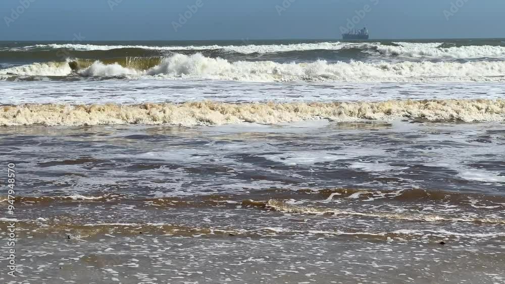 White surf with a cargo ship on the horizon White surf with a cargo ship on the horizon