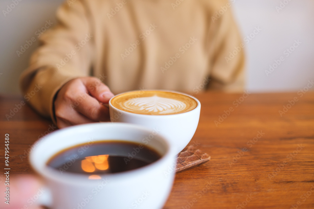 Closeup image of a couple people holding and drinking coffee together Closeup image of a couple people holding and drinking coffee together