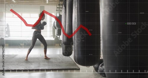 Boxing in gym, woman training with punching bag over financial graph animation