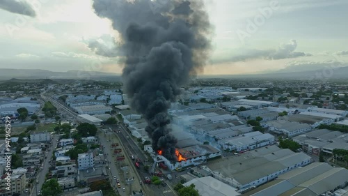 Fierce fire at a factory with a large black smoke cloud, showcasing the chaos and damage caused by the inferno