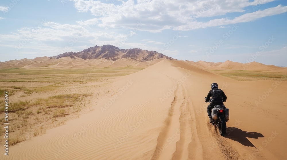 A motorcyclist rides on one wheel on the sand A motorcyclist rides on one wheel on the sand