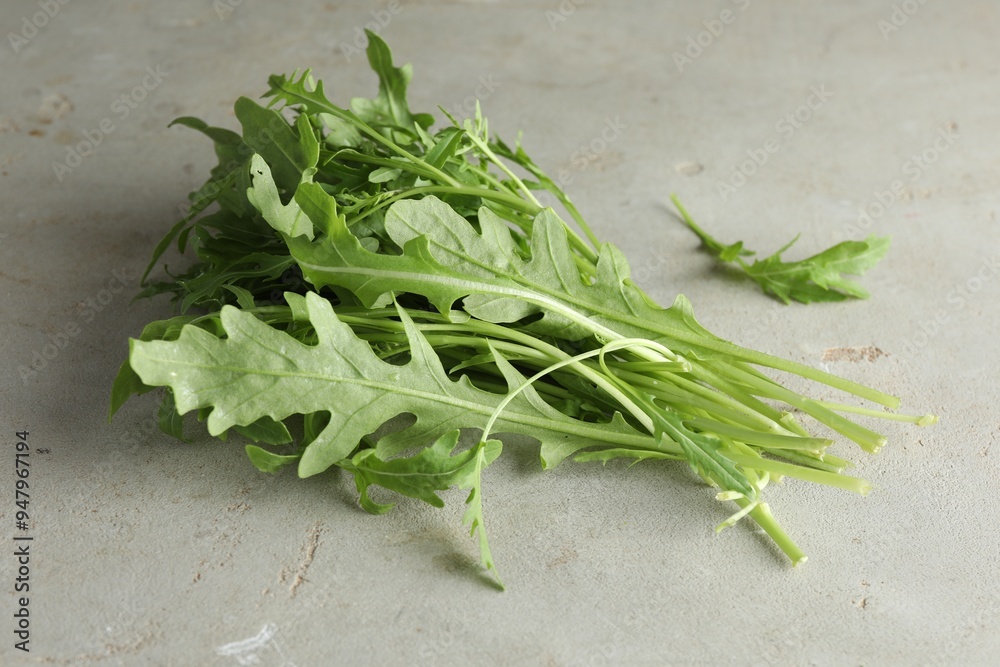 Many fresh arugula leaves on grey textured table Many fresh arugula leaves on grey textured table