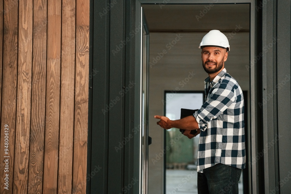 Showing the wooden house that is under construction. Industrial worker in warehouse Showing the wooden house that is under construction. Industrial worker in warehouse