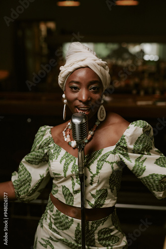 Sticker Self-confident young Black woman singing jazz song on stage in bar and looking a