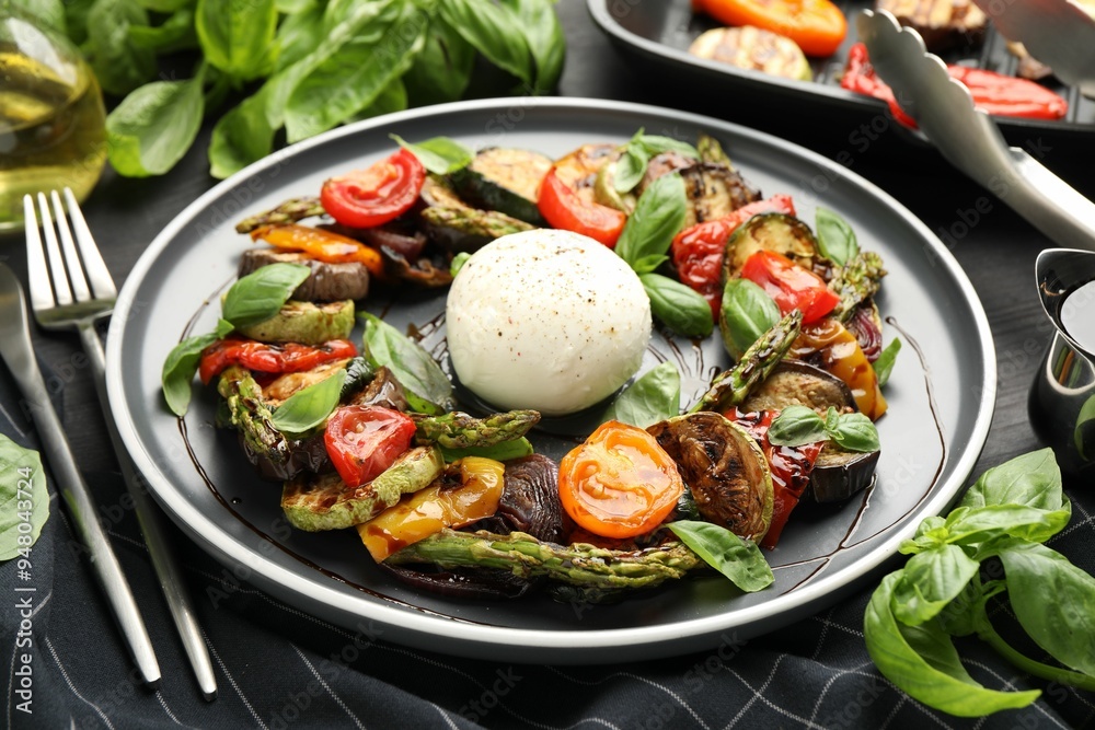 Tasty salad with grilled vegetables and mozzarella cheese served on black table Tasty salad with grilled vegetables and mozzarella cheese served on black table