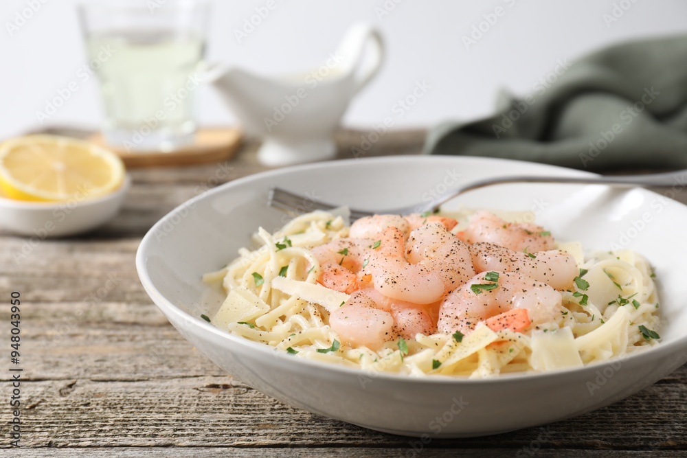 Delicious pasta with shrimps and cheese on wooden table, closeup Delicious pasta with shrimps and cheese on wooden table, closeup