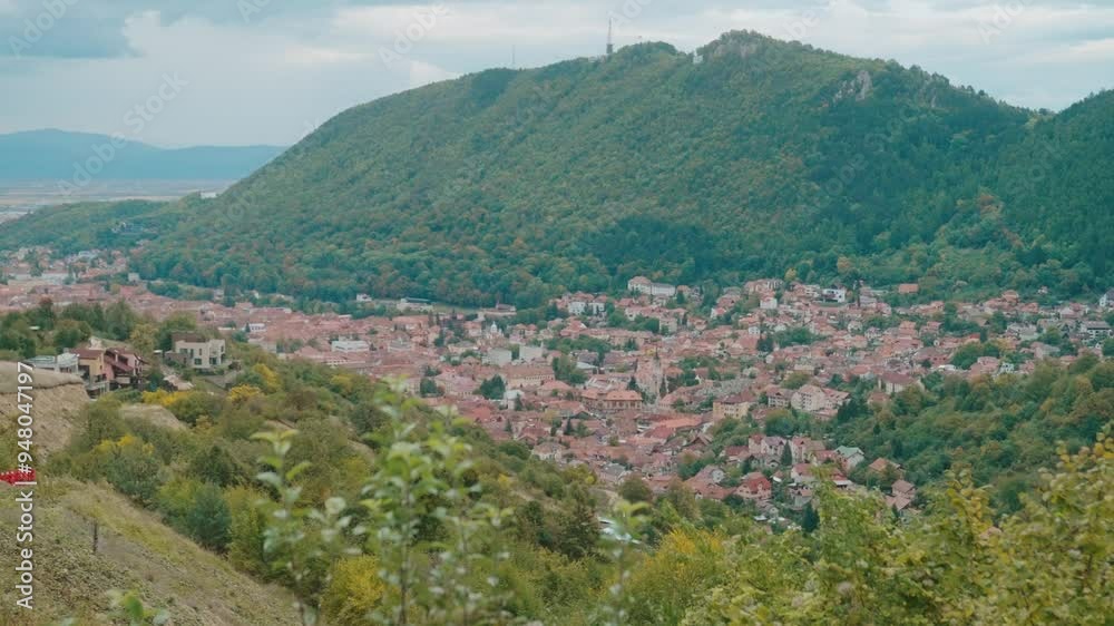 Small town nestled in a valley surrounded by lush green hills under a partly cloudy sky Small town nestled in a valley surrounded by lush green hills under a partly cloudy sky
