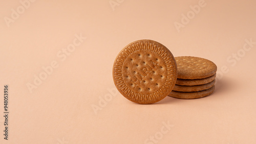 Maria biscuits on pink beige background. Trendy color of the year 2024 - Peach Fuzz. Copy space