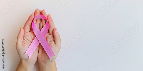 Wallpaper Mural Close-up of hands gently holding a pink ribbon, symbolizing support and awareness during Breast Cancer Awareness Month, with a minimalistic white background.
 Torontodigital.ca