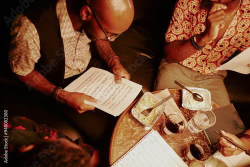 Photography High angle view of jazz band musicians learning song while having dinner in loca