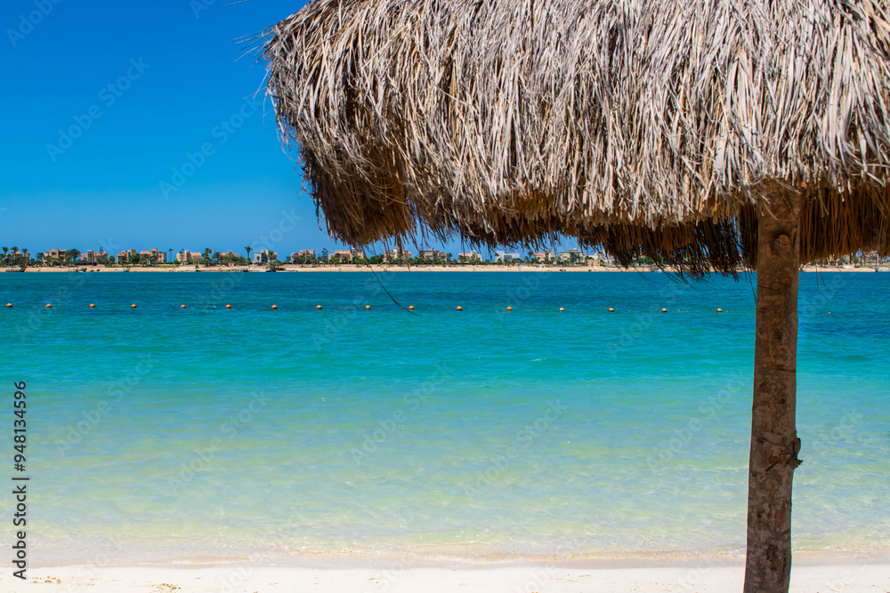 sunny beach scene with an umbrella, blue sea, and clear sky, perfect for summer vacation sunny beach scene with an umbrella, blue sea, and clear sky, perfect for summer vacation
