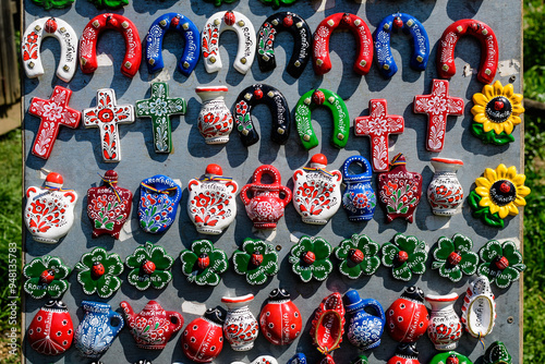Group of colourful hand painted mixed magnets and suvenirs displayed for sale at a traditional weekend market in Bucharest, Romania.