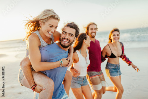 Friends laughing and having fun on the beach at sunset photo