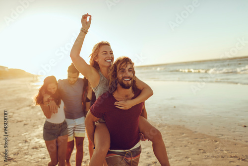Friends laughing and having fun on the beach at sunset