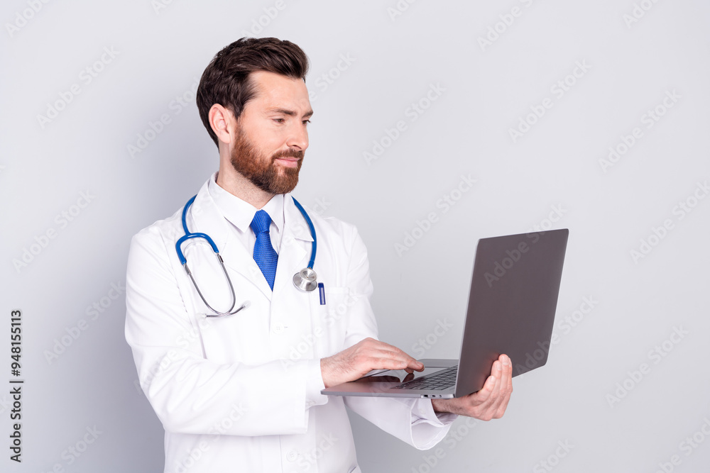 Portrait of experienced doctor man use laptop wear white coat isolated on grey color background Portrait of experienced doctor man use laptop wear white coat isolated on grey color background
