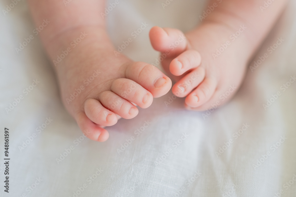 Tiny newborn infant baby feet and toes on white background. Soft newborn baby foot legs under the white blanket. Close up of infant barefeet. Maternity tenderness parenthood birthday. Happy Family Tiny newborn infant baby feet and toes on white background. Soft newborn baby foot legs under the white blanket. Close up of infant barefeet. Maternity tenderness parenthood birthday. Happy Family