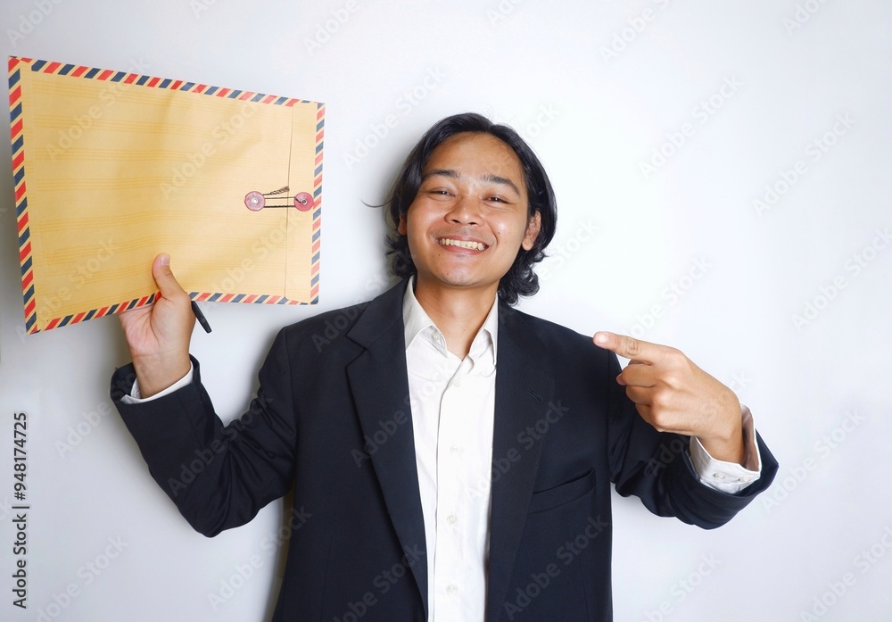 a young Indonesian man with long hair wearing a black suit carries documents required for work on an isolated white background a young Indonesian man with long hair wearing a black suit carries documents required for work on an isolated white background