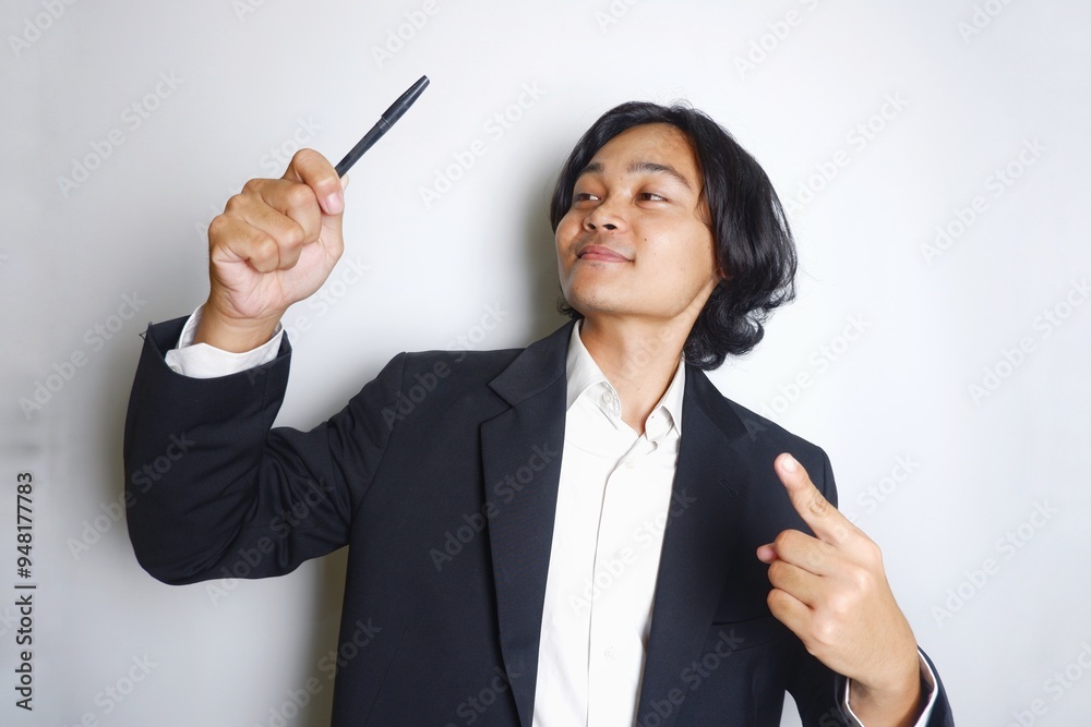 a young Indonesian man with long hair wearing a black suit carries documents required for work on an isolated white background a young Indonesian man with long hair wearing a black suit carries documents required for work on an isolated white background