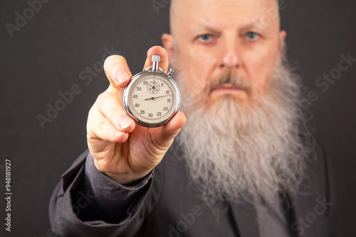 Foto distinguished man with a sizable gray beard displaying the time on a mechanical