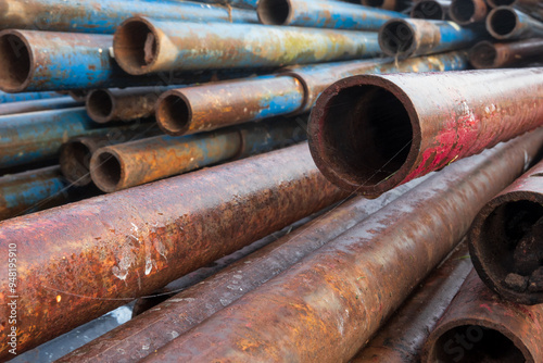 Perspective view of a pile of old stacked pipes for scaffolding installation. Background.