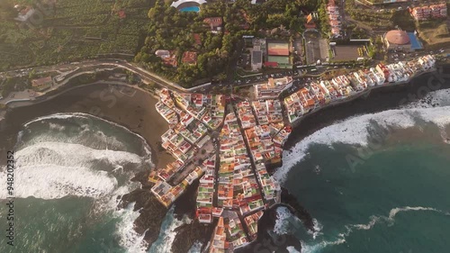 Aerial view of colorful rooftops and historic buildings along the shore with waves crashing, Charcones Punta Brava, Puerto de la Cruz, Tenerife, Spain. photo