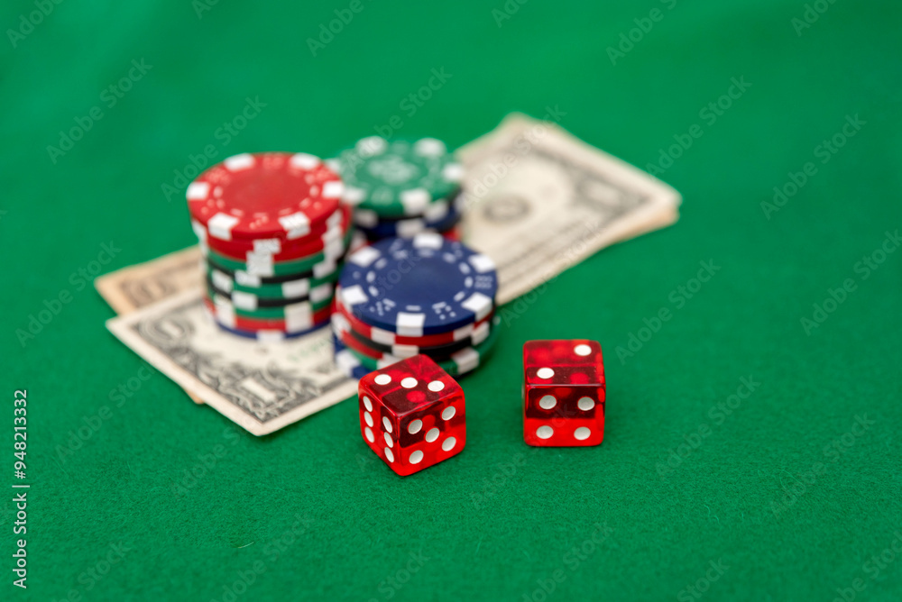 Poker Chips and Red Dice on a Stack of Dollar Bills on Green Felt Background Poker Chips and Red Dice on a Stack of Dollar Bills on Green Felt Background
