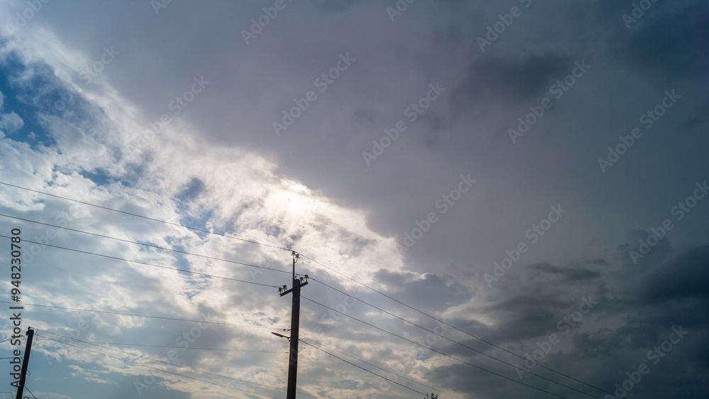 Evening skies with clouds and electric pole with wires Evening skies with clouds and electric pole with wires