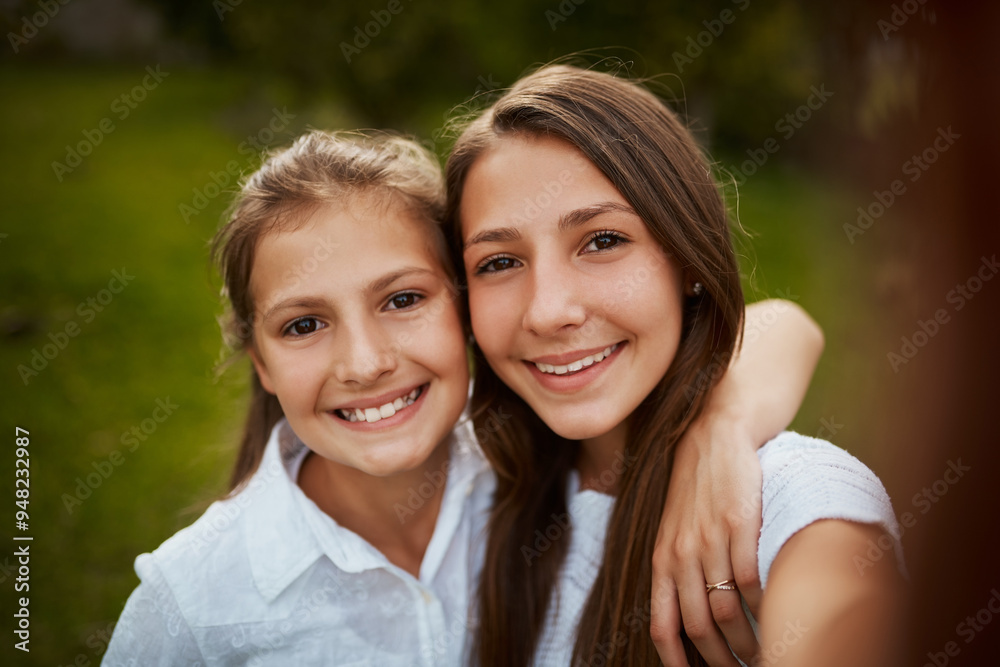 Obraz premium Happy girl, portrait and sisters with selfie in nature for photography, picture or outdoor memory together. Young, female person or siblings with smile for childhood moment or growth in backyard