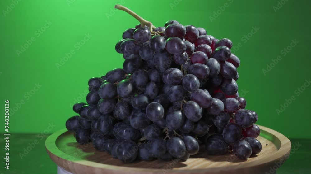 bunch of grapes raisins spinning on a wooden plate bunch of grapes raisins spinning on a wooden plate