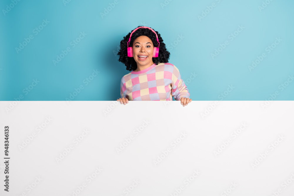 Photo portrait of pretty young girl headphones white empty space wear trendy pink plaid outfit isolated on blue color background Photo portrait of pretty young girl headphones white empty space wear trendy pink plaid outfit isolated on blue color background