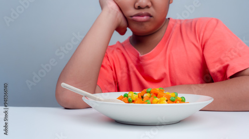 Children do not like to eat vegetables, Little cute boy refuses to eat healthy vegetables, Nutrition healthy eating habits for kids concept, Children do not like to eat vegetables. photo