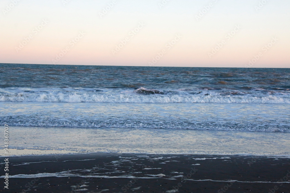 Sea landscape. Sea background at sunset with waves breaking on the beach. Concept of vacations, travel, calm, peace, relaxation. Sea landscape. Sea background at sunset with waves breaking on the beach. Concept of vacations, travel, calm, peace, relaxation.