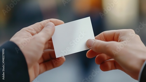 A close-up of an insurance broker business card being handed to a client.