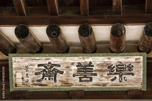 Jongno-gu, Seoul, South Korea - January 28, 2022: Low angle view of a signboard saying Naksunjae House on the eaves of a tile roof house at Changgyeonggung Palace photo