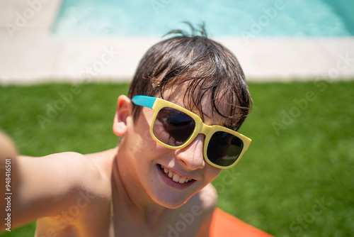 Selfie of happy young boy enjoying a summer day in a pool